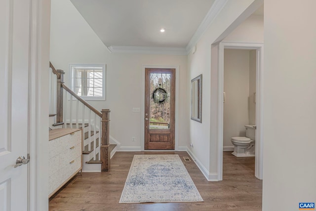foyer featuring stairway, wood finished floors, ornamental molding, baseboards, and recessed lighting