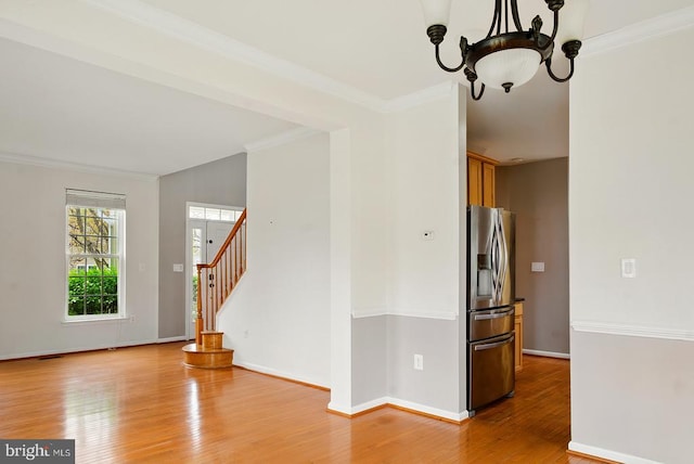 607 Woodruff Ln, Culpeper, VA 22701 - spare room with ornamental molding, light wood-style flooring, a chandelier, and stairway
