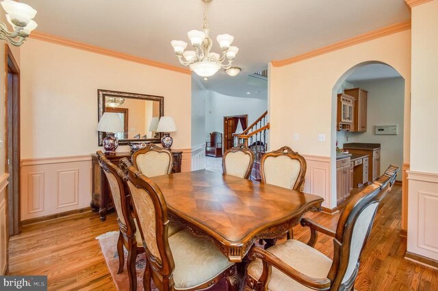 11425 Custers Trce, Spotsylvania, VA 22553 - dining space with a chandelier, light wood-style floors, arched walkways, wainscoting, and stairway