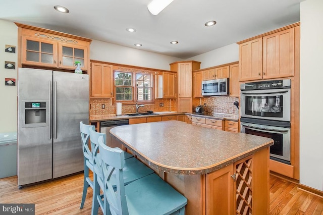 11425 Custers Trce, Spotsylvania, VA 22553 - kitchen with stainless steel appliances, a sink, light wood-type flooring, decorative backsplash, and dark countertops
