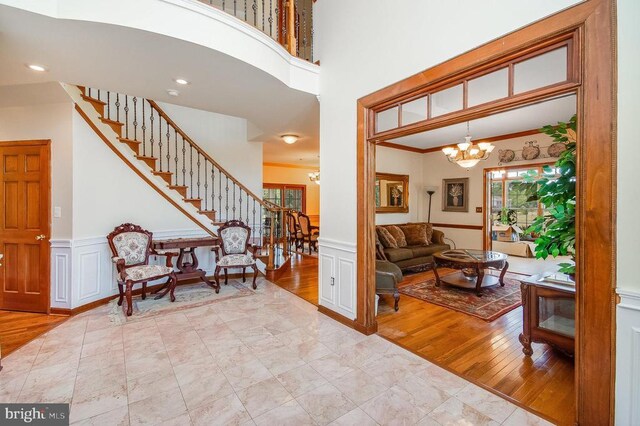 11425 Custers Trce, Spotsylvania, VA 22553 - foyer featuring a chandelier, a wainscoted wall, stairs, wood finished floors, and a decorative wall