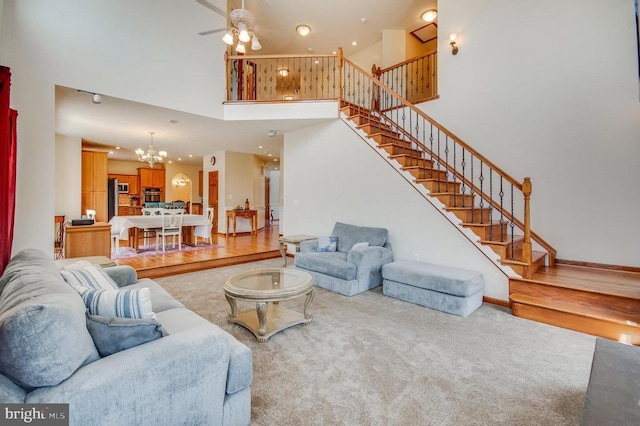 11425 Custers Trce, Spotsylvania, VA 22553 - living room featuring a towering ceiling, a chandelier, ceiling fan, stairs, and carpet floors