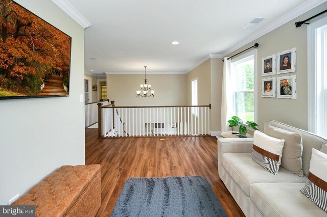  - living area featuring wood finished floors, a chandelier, crown molding, recessed lighting, and an upstairs landing