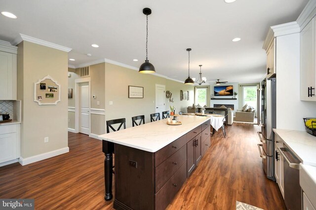  - kitchen with stainless steel appliances, a kitchen bar, open floor plan, recessed lighting, and dark wood-style floors