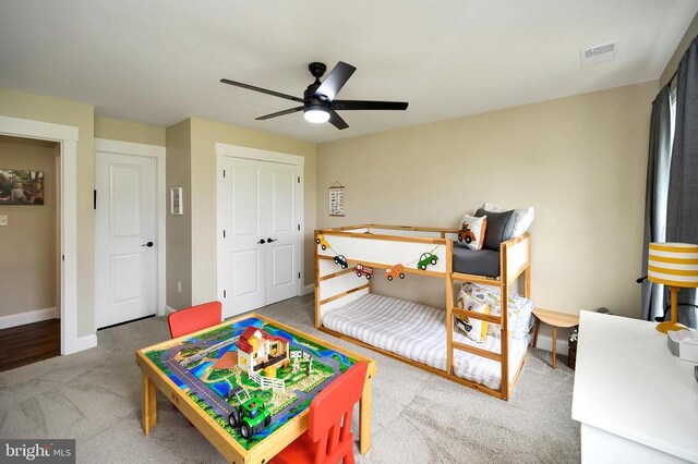 - carpeted bedroom with a closet, baseboards, and a ceiling fan