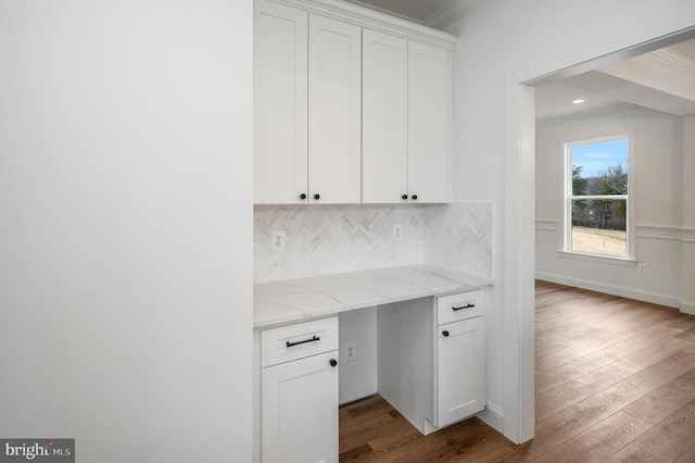  - unfurnished office with dark wood-type flooring, crown molding, recessed lighting, and built in study area