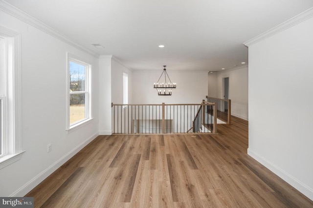  - spare room with a chandelier, wood finished floors, baseboards, crown molding, and recessed lighting