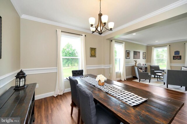  - dining area featuring a chandelier, dark wood-style floors, crown molding, and baseboards
