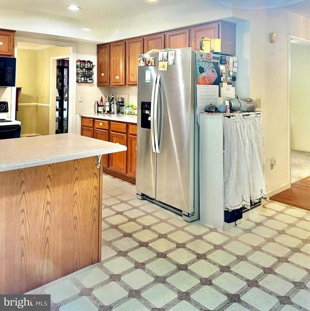 26 Magnolia Ct, Barboursville, VA 22923 - kitchen featuring light flooring, black microwave, stainless steel fridge, brown cabinets, and recessed lighting