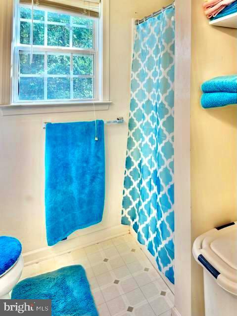 26 Magnolia Ct, Barboursville, VA 22923 - bathroom with toilet, healthy amount of natural light, a shower with curtain, and baseboards