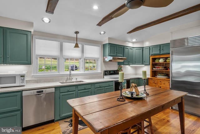  - kitchen featuring appliances with stainless steel finishes, green cabinetry, a sink, under cabinet range hood, and lofted ceiling