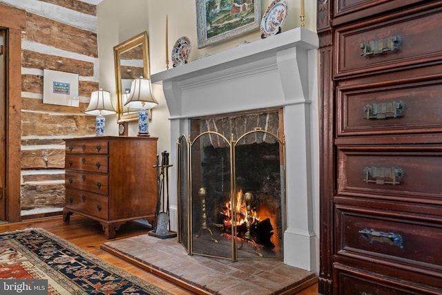  - detailed view of wood finished floors and a lit fireplace