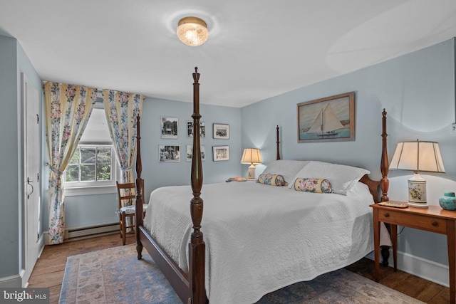  - bedroom with a baseboard heating unit and wood finished floors