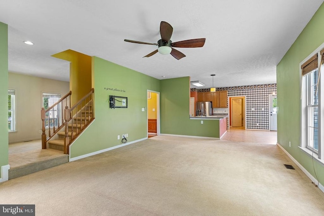 2703 Schumann St, Fredericksburg, VA 22408 - unfurnished living room featuring light carpet, a ceiling fan, stairway, plenty of natural light, and wallpapered walls