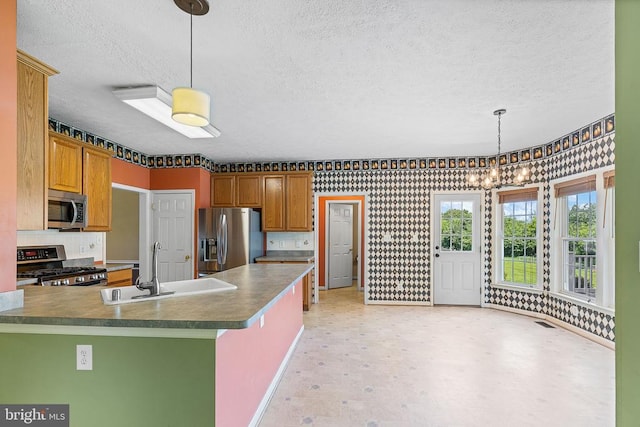 2703 Schumann St, Fredericksburg, VA 22408 - kitchen with appliances with stainless steel finishes, a textured ceiling, a peninsula, light flooring, and pendant lighting