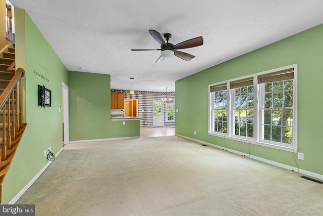 2703 Schumann St, Fredericksburg, VA 22408 - unfurnished living room with a ceiling fan, stairway, light carpet, and a textured ceiling