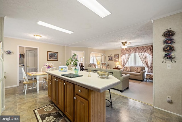 731 Bluewater Blvd S, Mineral, VA 23117 - kitchen with a center island, a textured ceiling, baseboards, a kitchen bar, and brown cabinets