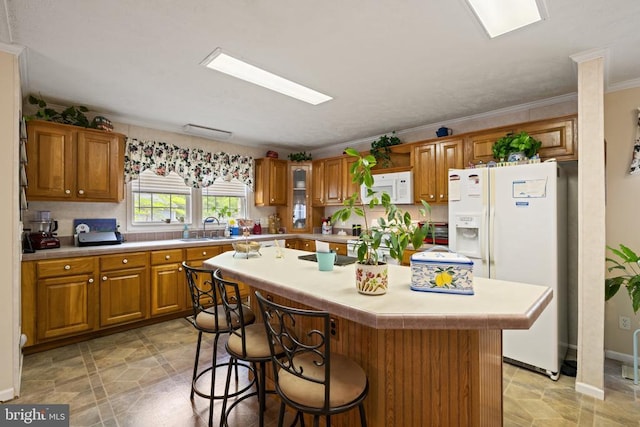 731 Bluewater Blvd S, Mineral, VA 23117 - kitchen with a breakfast bar, white appliances, a sink, brown cabinets, and light countertops