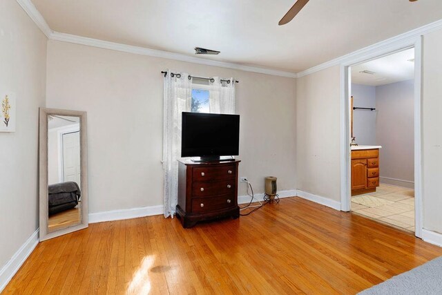 bedroom featuring crown molding, light hardwood / wood-style floors, and ensuite bathroom