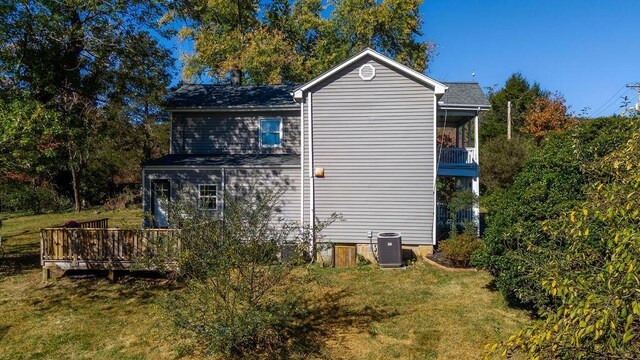 view of home's exterior with a deck, central AC unit, and a lawn