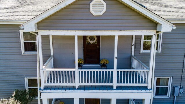 view of exterior entry with a balcony