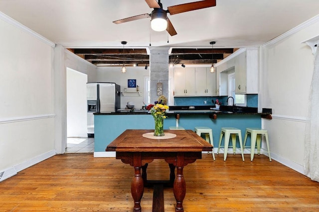 kitchen featuring white cabinetry, stainless steel fridge, sink, and light hardwood / wood-style flooring