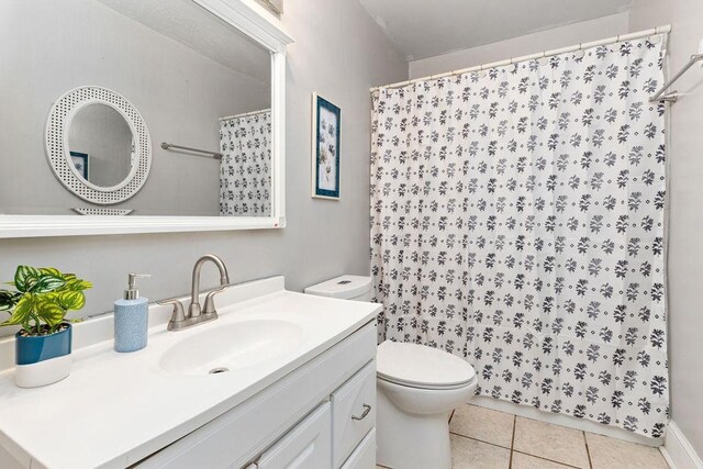 bathroom featuring a shower with curtain, tile patterned floors, toilet, and vanity