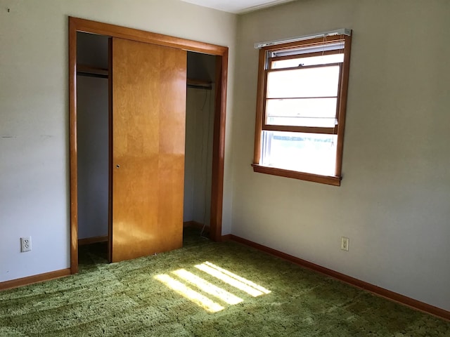 unfurnished bedroom with carpet flooring, a closet, multiple windows, and baseboards