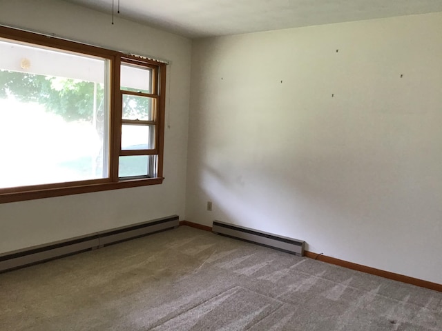 unfurnished room featuring a baseboard radiator, carpet, and baseboards