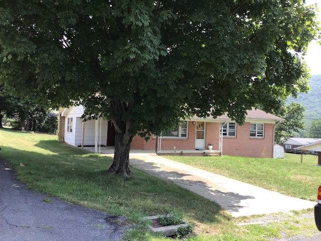 view of front of house with a front lawn, concrete driveway, and brick siding