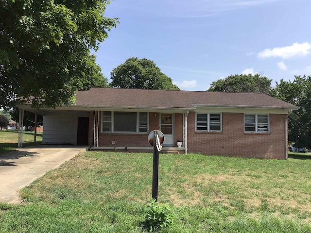 ranch-style house with concrete driveway, a carport, a front lawn, and brick siding