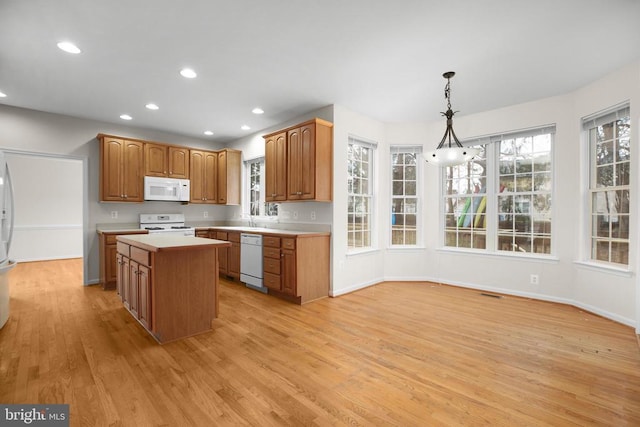 11218 Glen Park Dr, Fredericksburg, VA 22407 - kitchen with white appliances, light wood-type flooring, light countertops, a kitchen island, and healthy amount of natural light