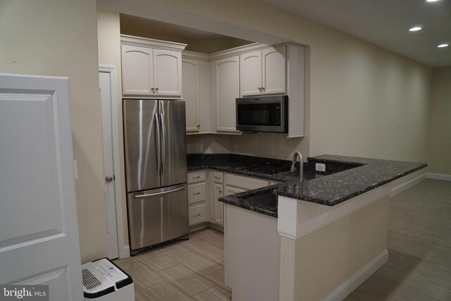 11218 Glen Park Dr, Fredericksburg, VA 22407 - kitchen with appliances with stainless steel finishes, a peninsula, recessed lighting, dark stone counters, and baseboards