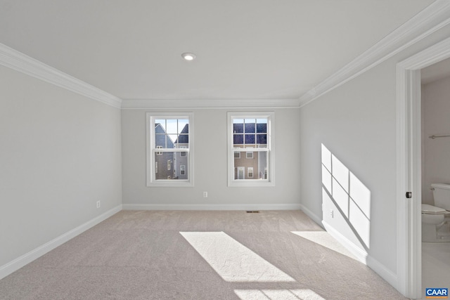 spare room with crown molding, light carpet, baseboards, and visible vents