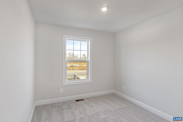 spare room with baseboards, visible vents, and carpet floors