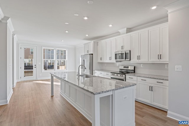 kitchen with an island with sink, white cabinetry, appliances with stainless steel finishes, and a sink