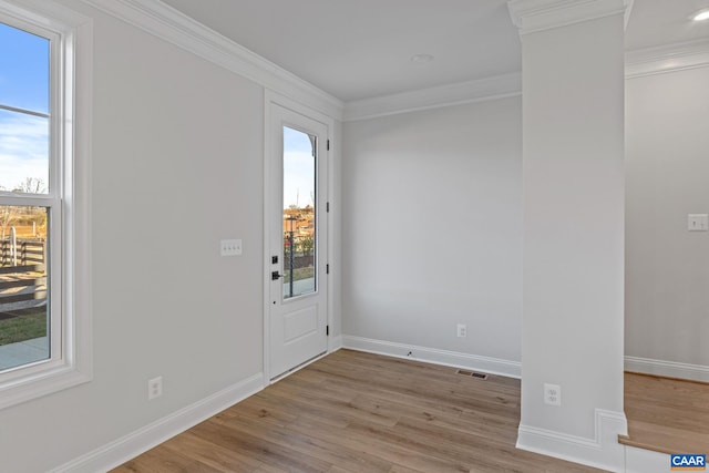 entryway featuring wood finished floors, baseboards, and ornamental molding