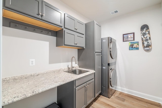 237 Ridgeline Dr, Waynesboro, VA 22980 - laundry area featuring estacked washer and dryer, light wood finished floors, cabinet space, and baseboards