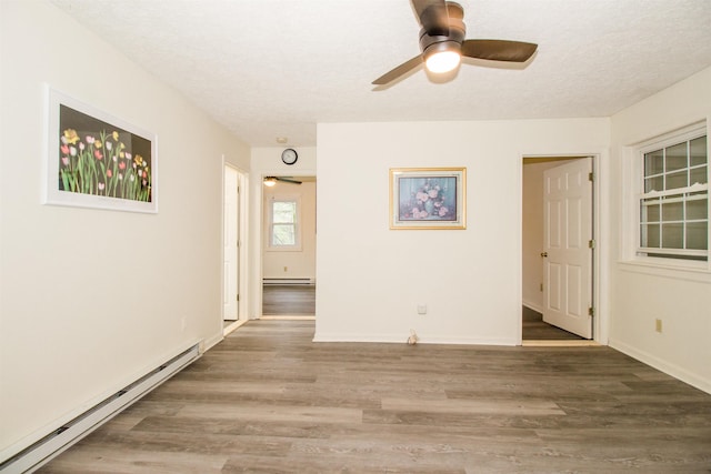 101 Sharp Hill Ln, Hinton, VA 22831 - unfurnished room featuring a ceiling fan, a baseboard radiator, baseboard heating, a textured ceiling, and wood finished floors