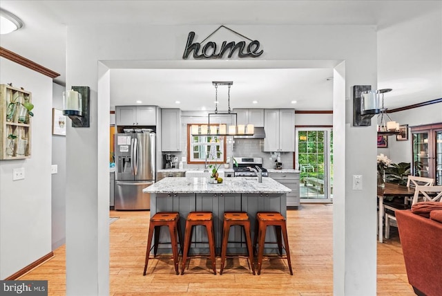 11311 Crown Ct, Fredericksburg, VA 22407 - kitchen featuring stainless steel appliances, gray cabinetry, light wood finished floors, a kitchen bar, and decorative backsplash