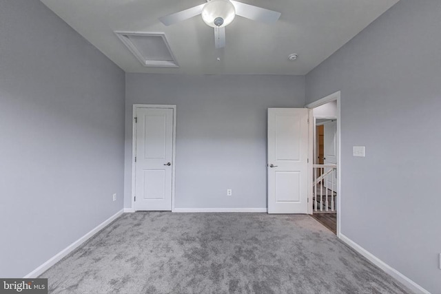  - unfurnished bedroom with attic access, carpet flooring, and ceiling fan