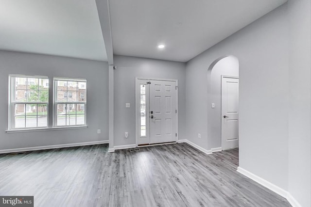  - entryway featuring arched walkways and wood finished floors