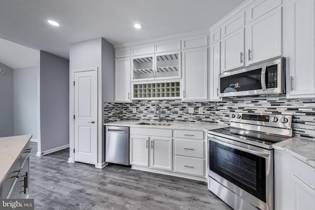  - kitchen featuring stainless steel appliances, white cabinetry, backsplash, and recessed lighting