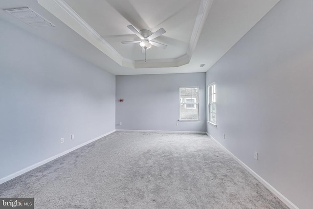  - carpeted empty room featuring a raised ceiling, a ceiling fan, and crown molding