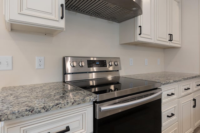 640 Greenwood St, Rockingham, VA 22801 - kitchen with stainless steel range with electric cooktop, custom exhaust hood, white cabinetry, and light stone countertops