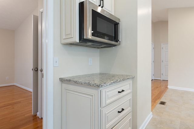 640 Greenwood St, Rockingham, VA 22801 - kitchen featuring stainless steel microwave, light wood-type flooring, baseboards, and light stone counters