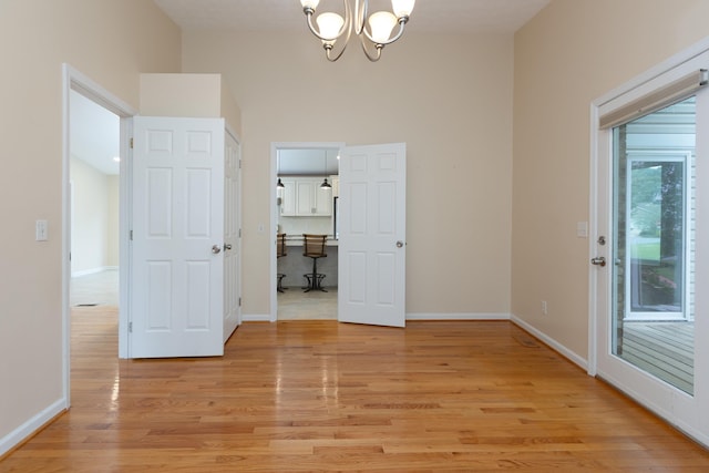 640 Greenwood St, Rockingham, VA 22801 - empty room with a chandelier, light wood-style floors, baseboards, and a high ceiling