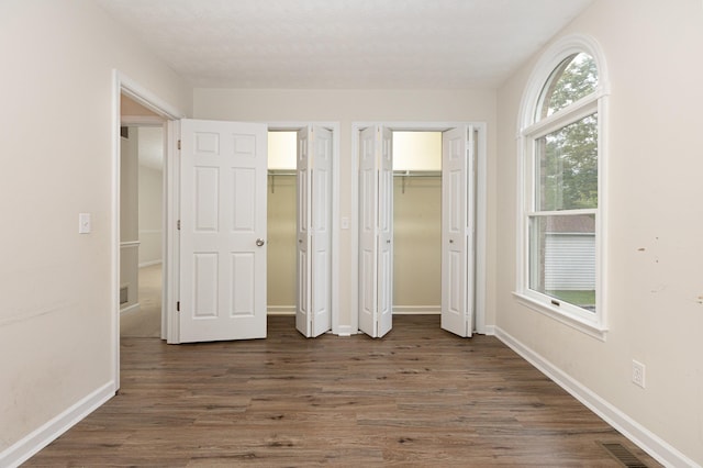 640 Greenwood St, Rockingham, VA 22801 - unfurnished bedroom with two closets, dark wood-type flooring, and baseboards