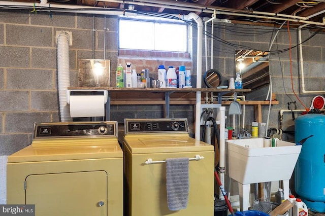 laundry room with a sink, washing machine and dryer, and laundry area