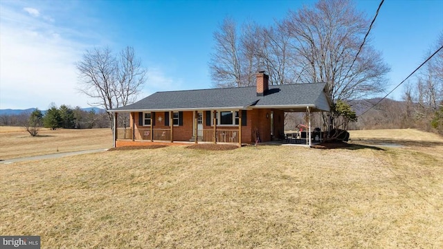 ranch-style home with a porch, a chimney, a front yard, and roof with shingles